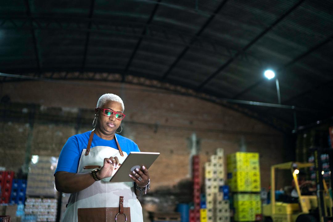 Woman in a warehouse using tablet to order supplies